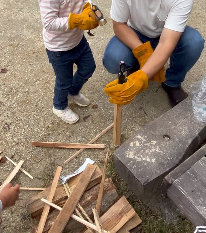 クサビを押さえる親と、ハンマーを持つ子ども