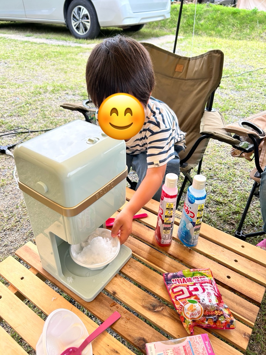かき氷メーカーで自分でかき氷を作っている子ども