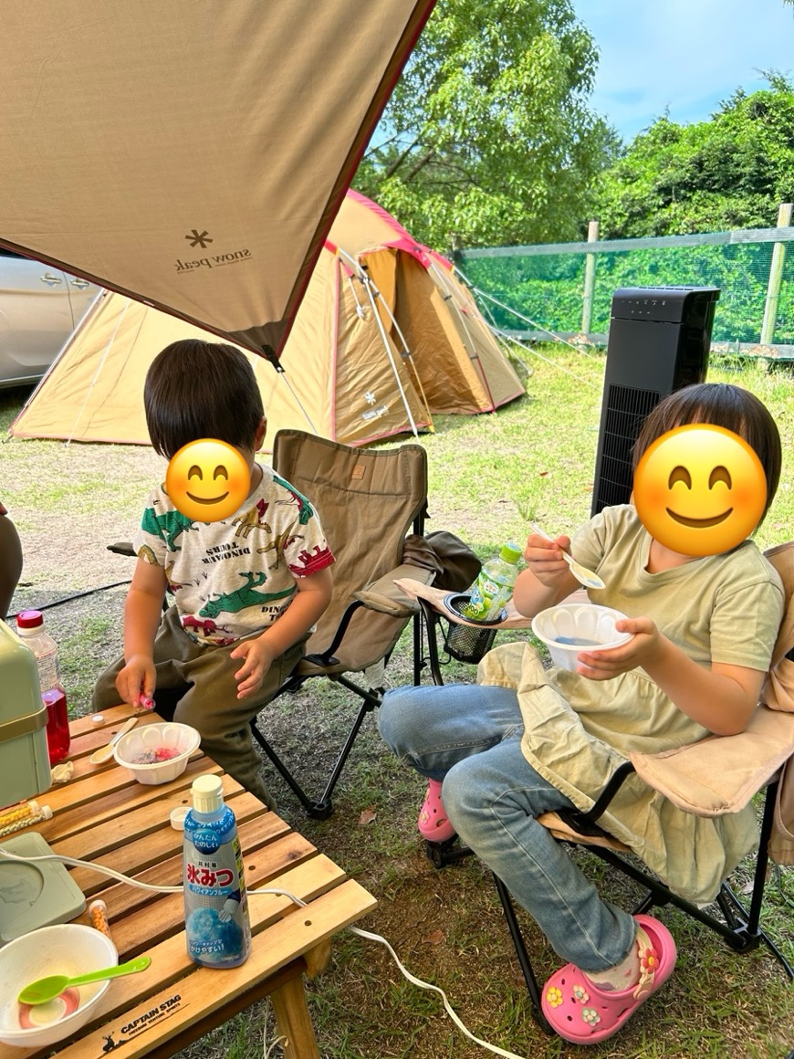 タープの下でかき氷を食べる子どもたち