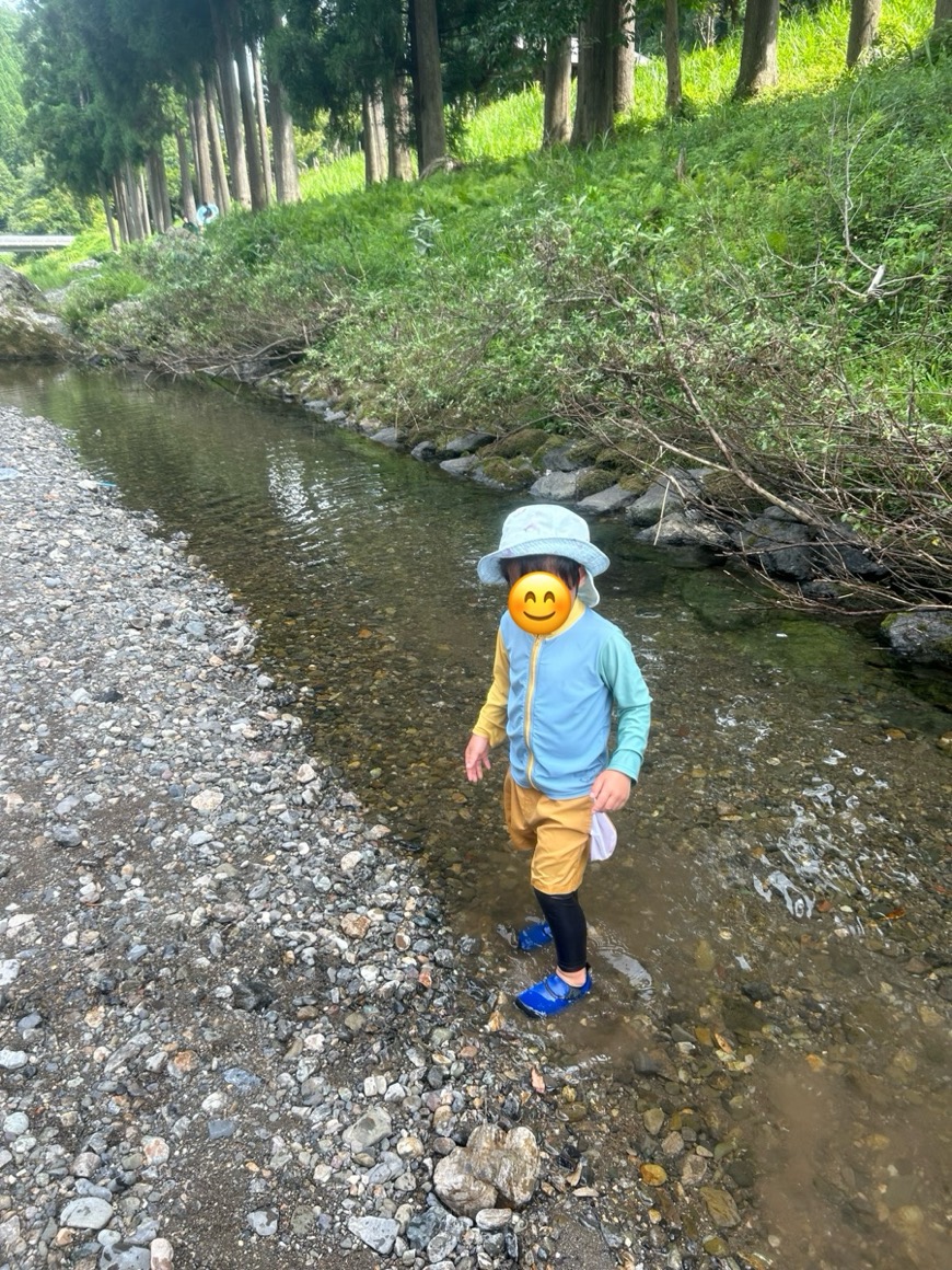 キャンプ場のそばの川を歩く子ども