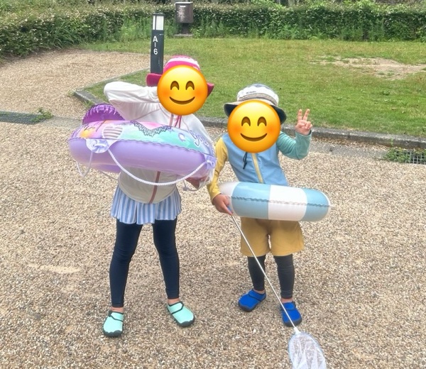 浮き輪と網を持った子ども2人。帽子、ラッシュガード、スパッツ、マリンシューズ姿