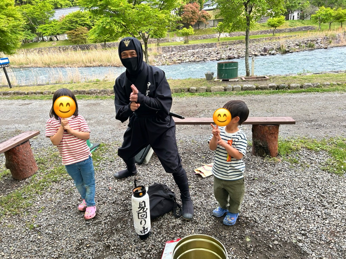 黒い忍者の衣装の人と、忍者のポーズをする子ども2人