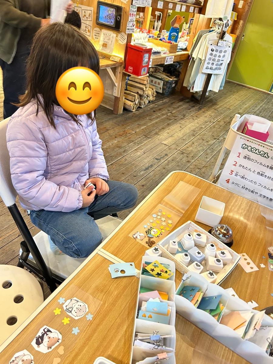 机に並んだ材料で、ランタンを作る女の子